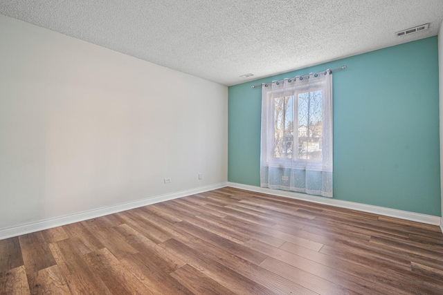 spare room with hardwood / wood-style flooring and a textured ceiling