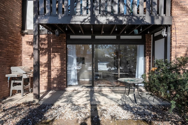 view of patio with a grill and a balcony