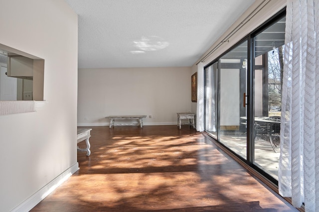 corridor featuring hardwood / wood-style flooring and a textured ceiling