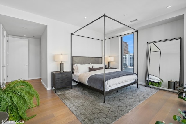 bedroom featuring wood-type flooring and access to outside