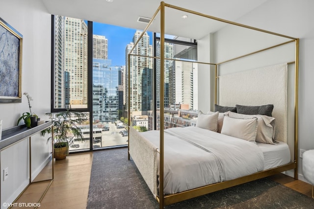 bedroom with access to outside, dark hardwood / wood-style floors, and floor to ceiling windows