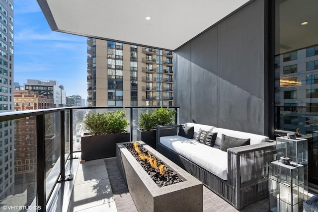 balcony featuring an outdoor living space with a fire pit