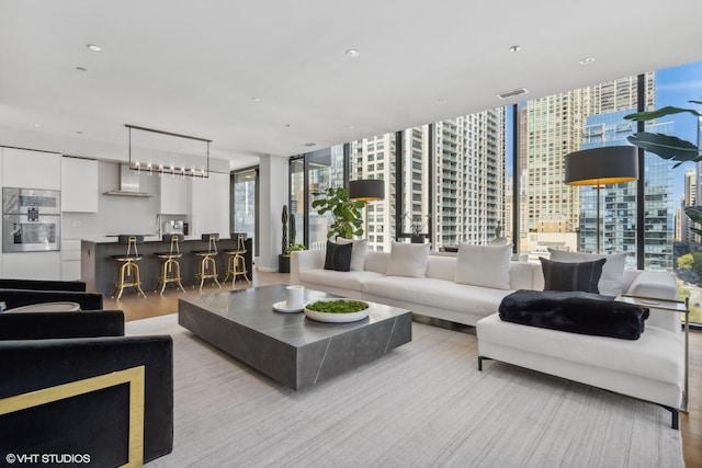 living room featuring floor to ceiling windows, light hardwood / wood-style flooring, plenty of natural light, and sink