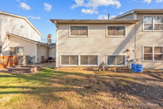 rear view of property with a yard and central AC unit