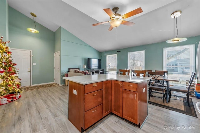 kitchen featuring ceiling fan, high vaulted ceiling, light hardwood / wood-style floors, and decorative light fixtures