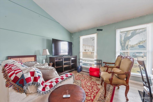 living room with hardwood / wood-style floors, a wealth of natural light, and vaulted ceiling