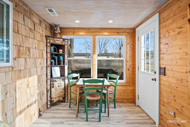 interior space with wood walls, light hardwood / wood-style flooring, and wooden ceiling