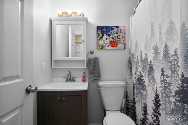 bathroom featuring curtained shower, toilet, and vanity