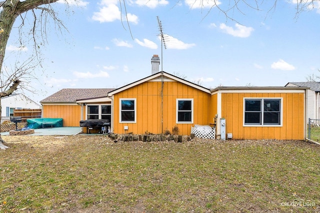 back of house with a patio area and a lawn