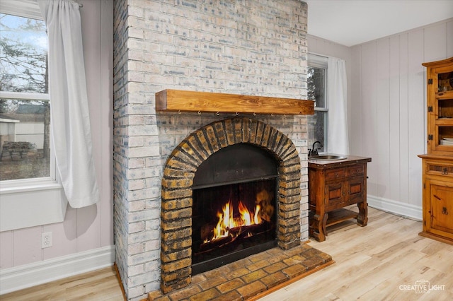 interior details featuring sink, hardwood / wood-style flooring, and a fireplace