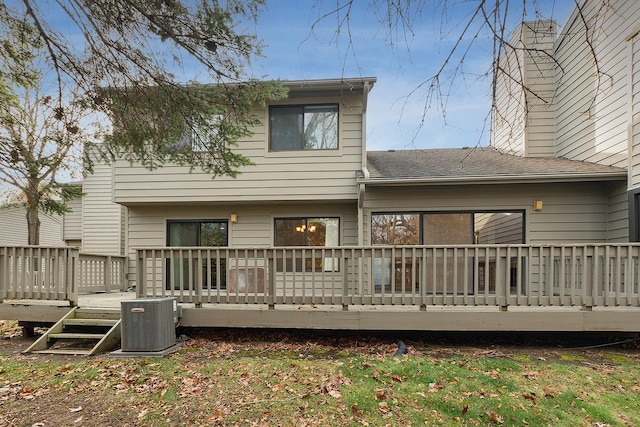 rear view of property featuring a deck and central AC