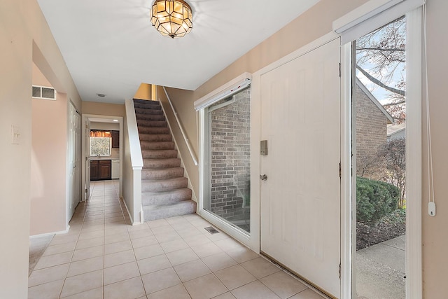 foyer with light tile patterned floors and a wealth of natural light