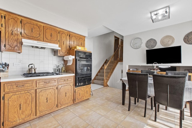 kitchen featuring light tile patterned flooring, backsplash, and stainless steel gas cooktop