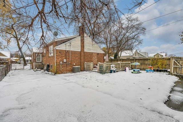 snow covered rear of property with cooling unit