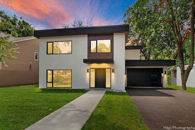 contemporary house featuring a lawn and a garage