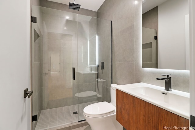 bathroom featuring backsplash, vanity, a shower with shower door, and toilet