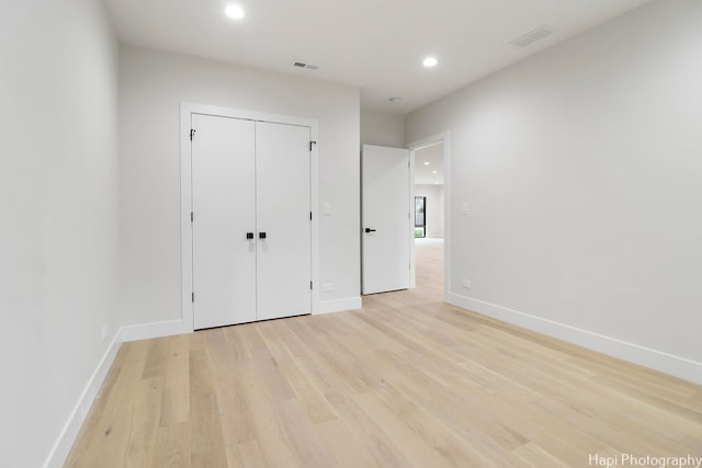 unfurnished bedroom with light hardwood / wood-style floors and a closet