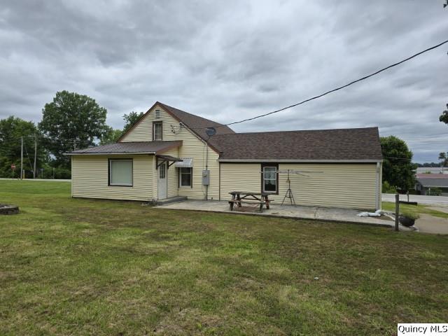 rear view of house featuring a patio and a lawn