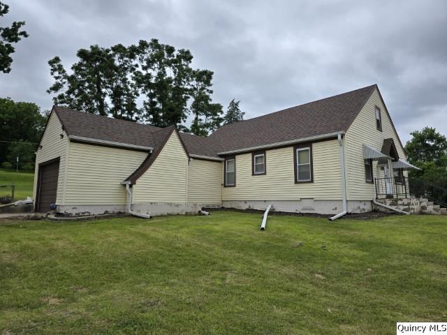 view of side of home with a garage and a lawn