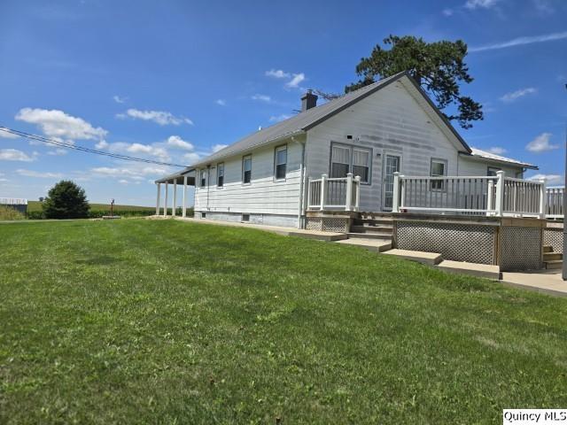 view of front of home with a wooden deck and a front yard