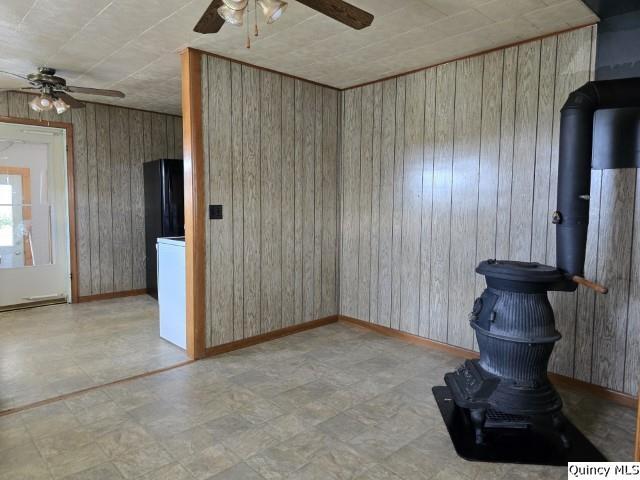 spare room featuring ceiling fan and wooden walls