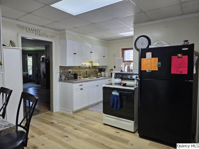 kitchen featuring white cabinetry, sink, electric range, black fridge, and light wood-type flooring