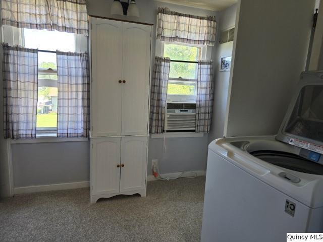 laundry area with cooling unit, cabinets, washer / dryer, and light colored carpet