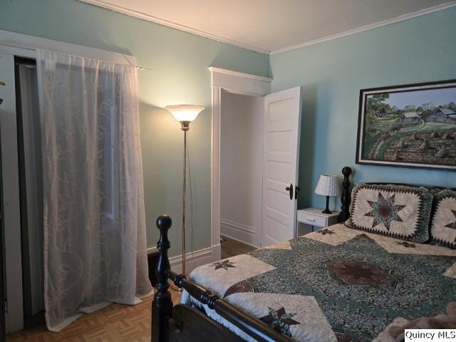 bedroom featuring crown molding and parquet flooring