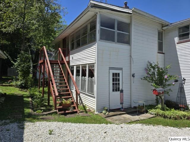 back of property with a sunroom