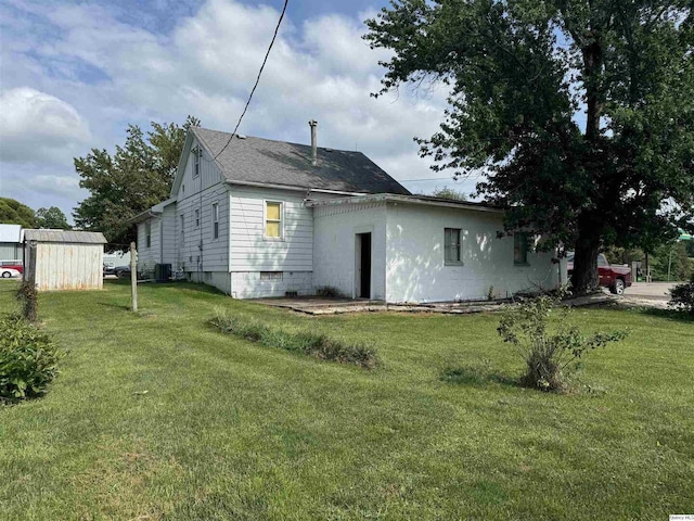 view of side of property featuring central AC, a shed, and a lawn