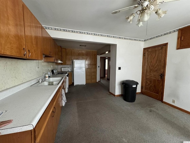 kitchen featuring ceiling fan, white appliances, sink, and dark colored carpet