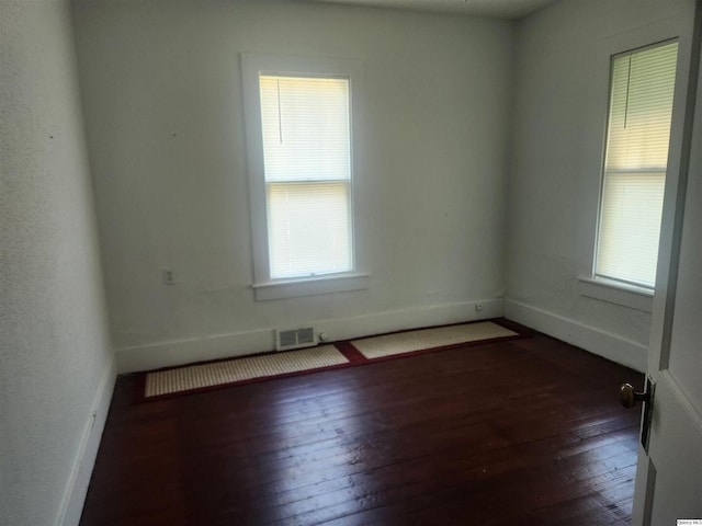 unfurnished room featuring dark hardwood / wood-style floors and a wealth of natural light