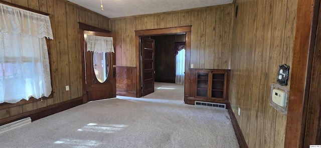 entryway featuring light carpet and wood walls