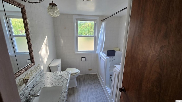 bathroom featuring toilet, sink, tile walls, and walk in shower