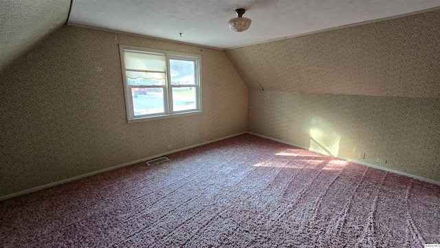 additional living space featuring lofted ceiling and carpet flooring