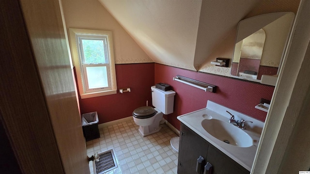 bathroom featuring vanity, vaulted ceiling, and toilet