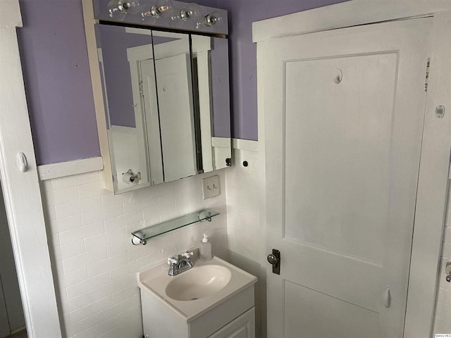 bathroom with vanity and tile walls