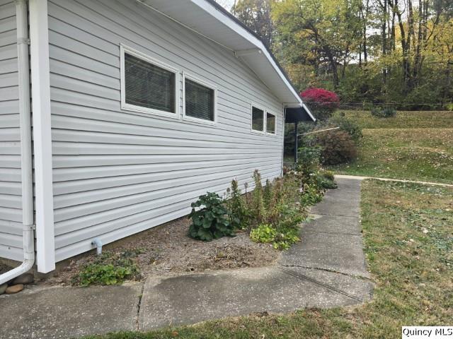 view of side of home with a yard