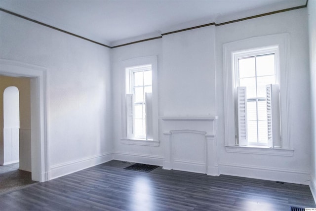 unfurnished room with ornamental molding, a wealth of natural light, and dark hardwood / wood-style flooring