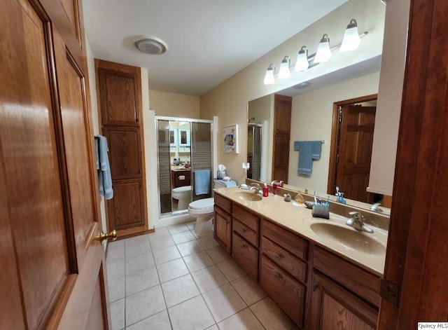 bathroom featuring tile patterned floors, toilet, an enclosed shower, a bidet, and vanity