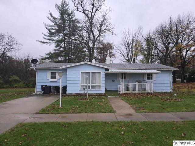 ranch-style home with a front yard and covered porch