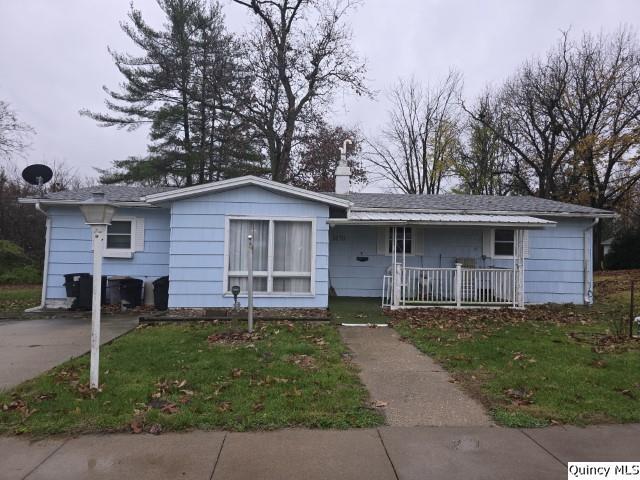 ranch-style house with covered porch and a front lawn