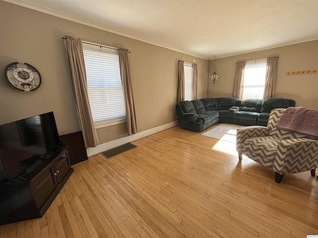 living room with ornamental molding and light hardwood / wood-style flooring