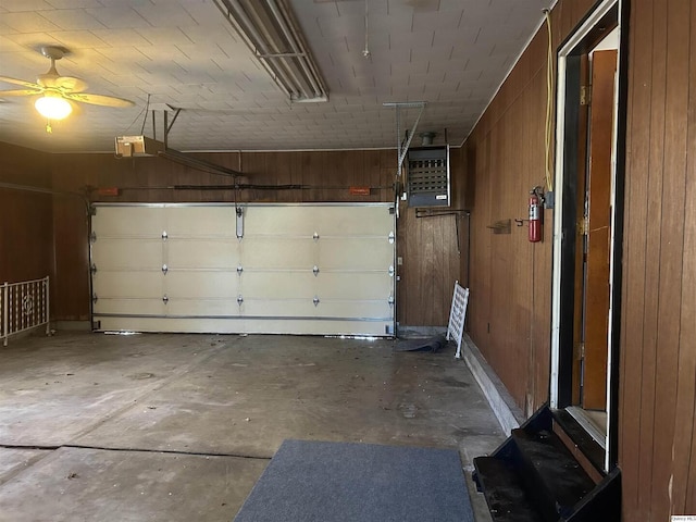 garage with a garage door opener and wood walls