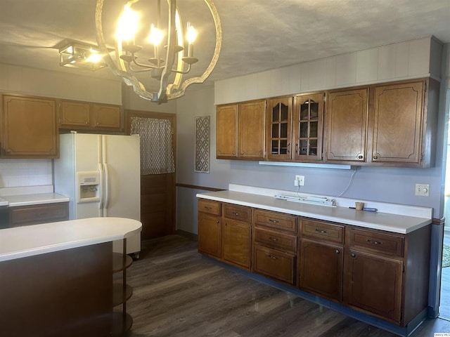 kitchen with a notable chandelier, dark hardwood / wood-style floors, hanging light fixtures, and white fridge with ice dispenser