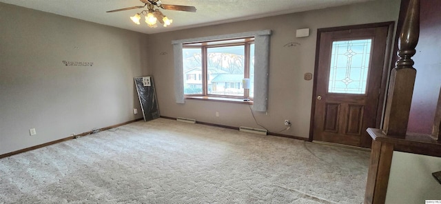 carpeted foyer entrance featuring ceiling fan and baseboard heating