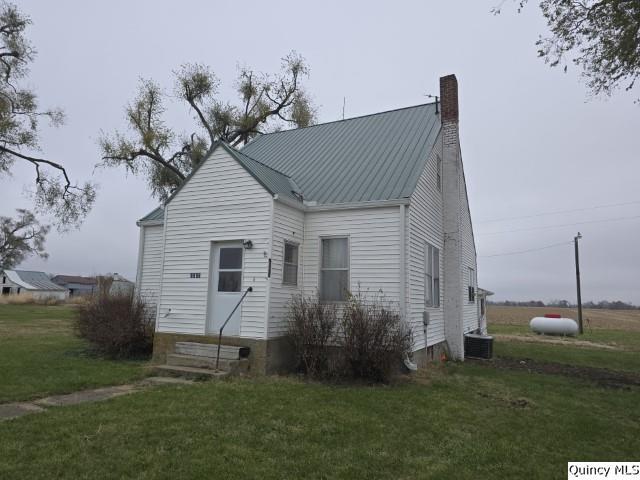 view of front facade featuring central AC and a front yard