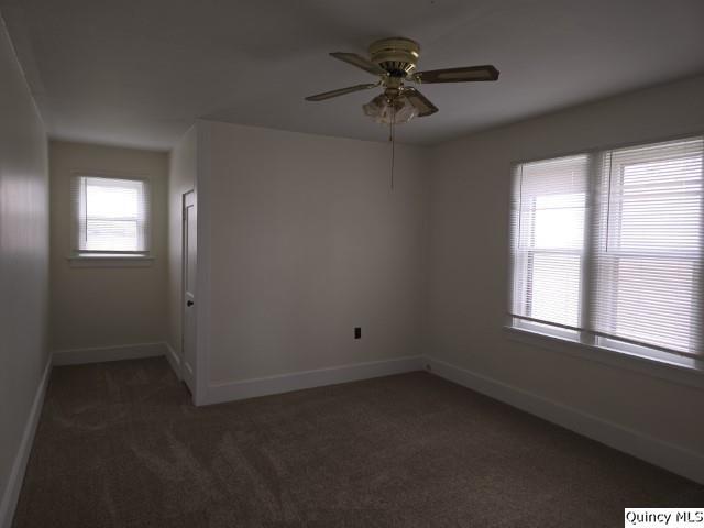 carpeted spare room with ceiling fan