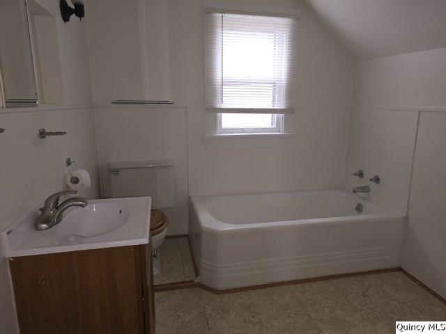 bathroom featuring lofted ceiling, toilet, and vanity