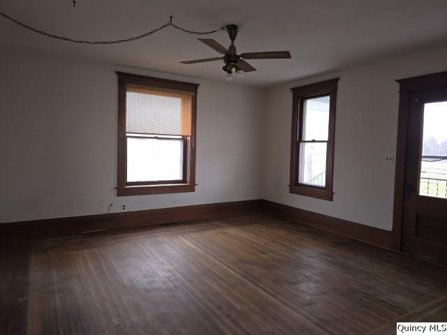 unfurnished room featuring dark wood-type flooring and ceiling fan